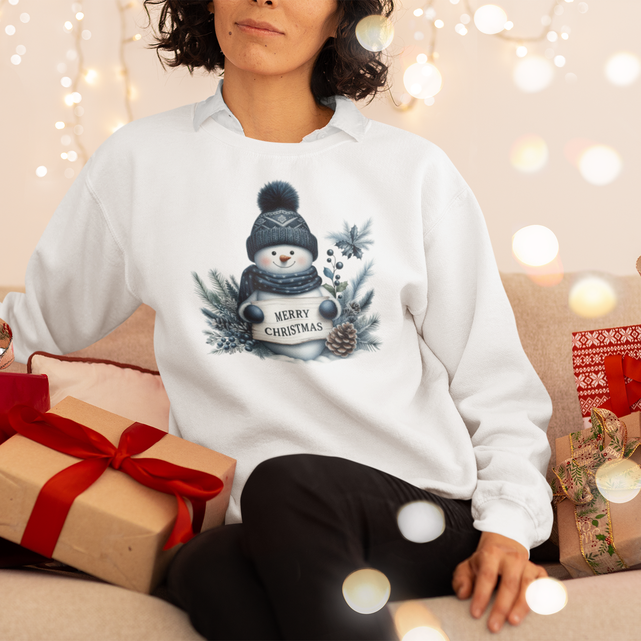 Person wearing a white sweatshirt with a Christmas design, surrounded by festive decorations and presents.