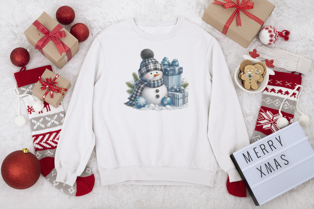White sweatshirt with a snowman design surrounded by Christmas decorations on a white background