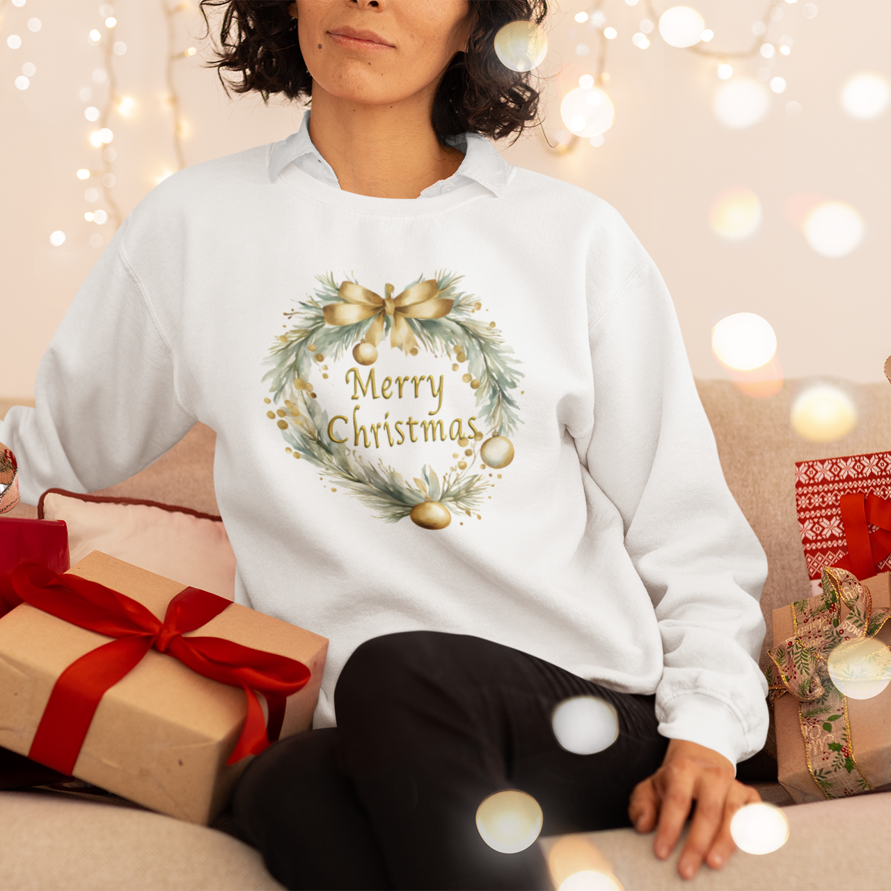 Person wearing a white sweatshirt with a Christmas design, surrounded by gift boxes and lights.