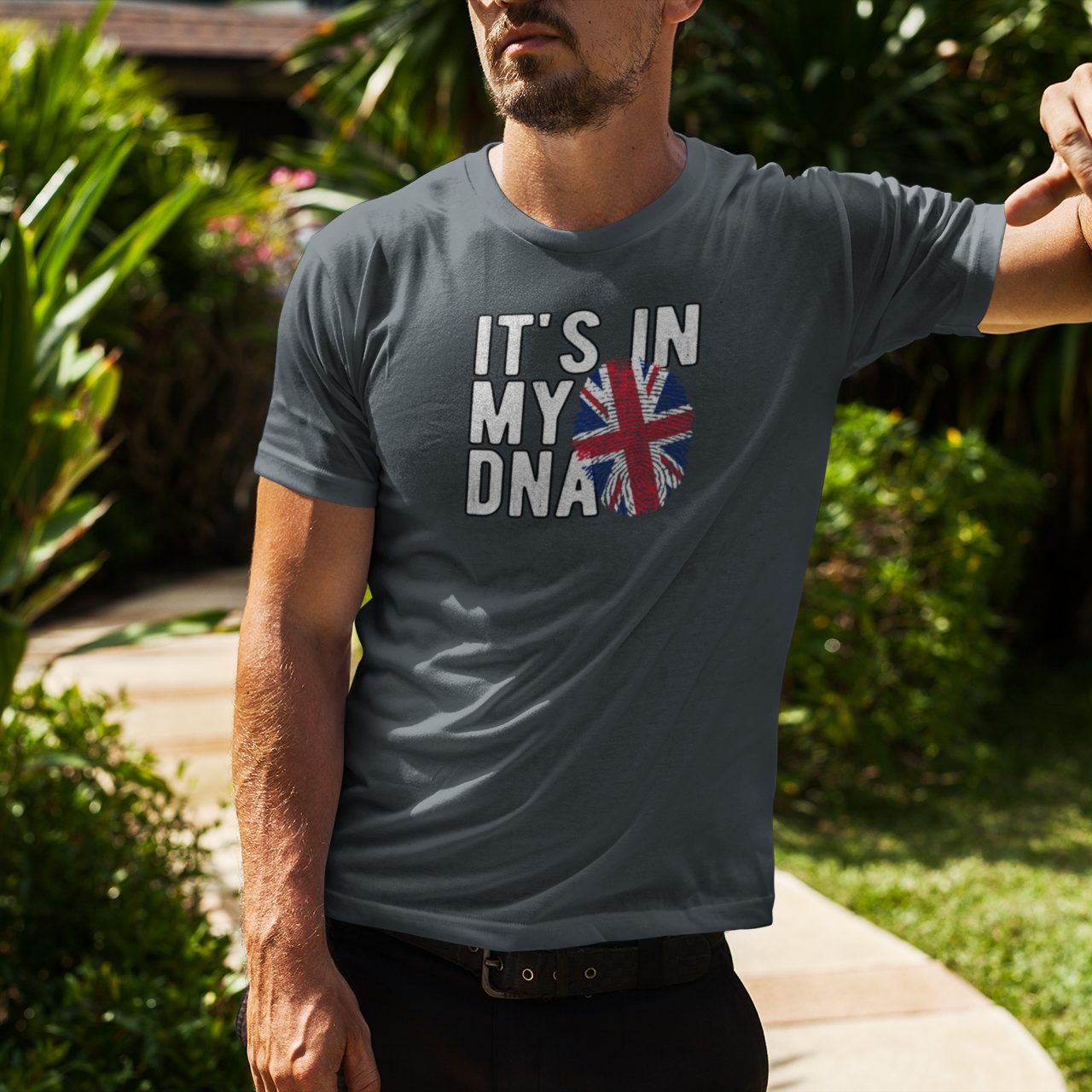 Man wearing a t-shirt with 'It's in my DNA' and a Union Jack design outdoors.