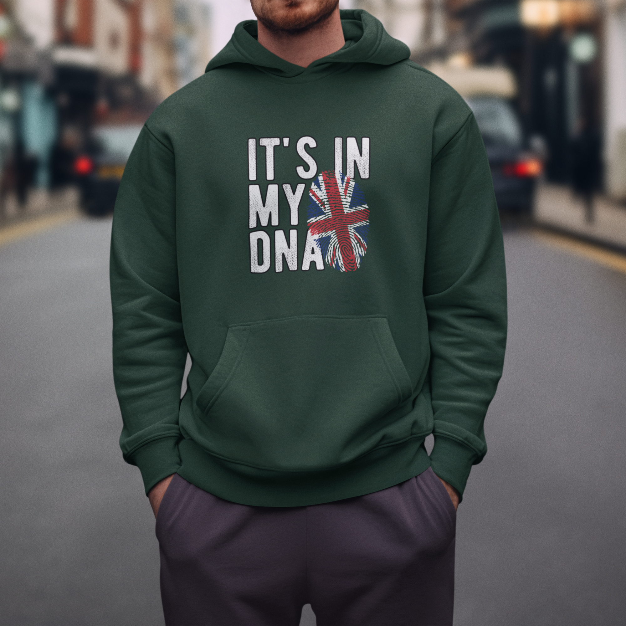 Person wearing a green hoodie with text and a flag design on a city street.