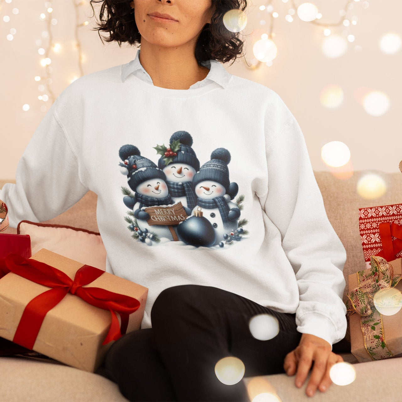 Person wearing a white sweater with Christmas-themed design surrounded by presents and lights