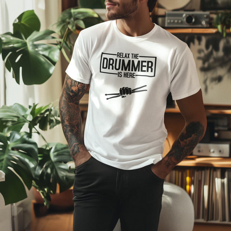 Man wearing a white t-shirt with 'Relax, the drummer is here' text in a room with plants and records.