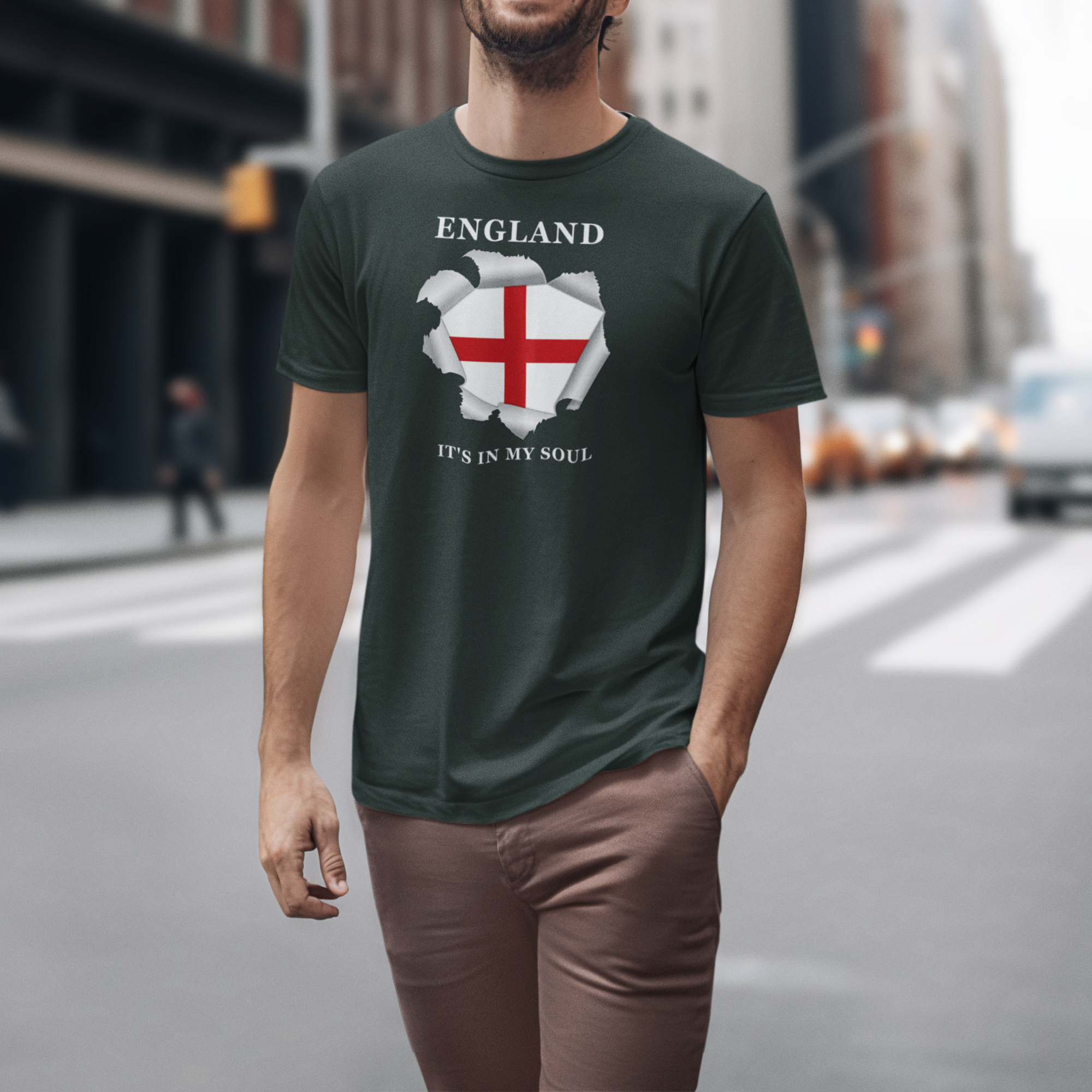 Person wearing a green t-shirt with an England design on a city street.