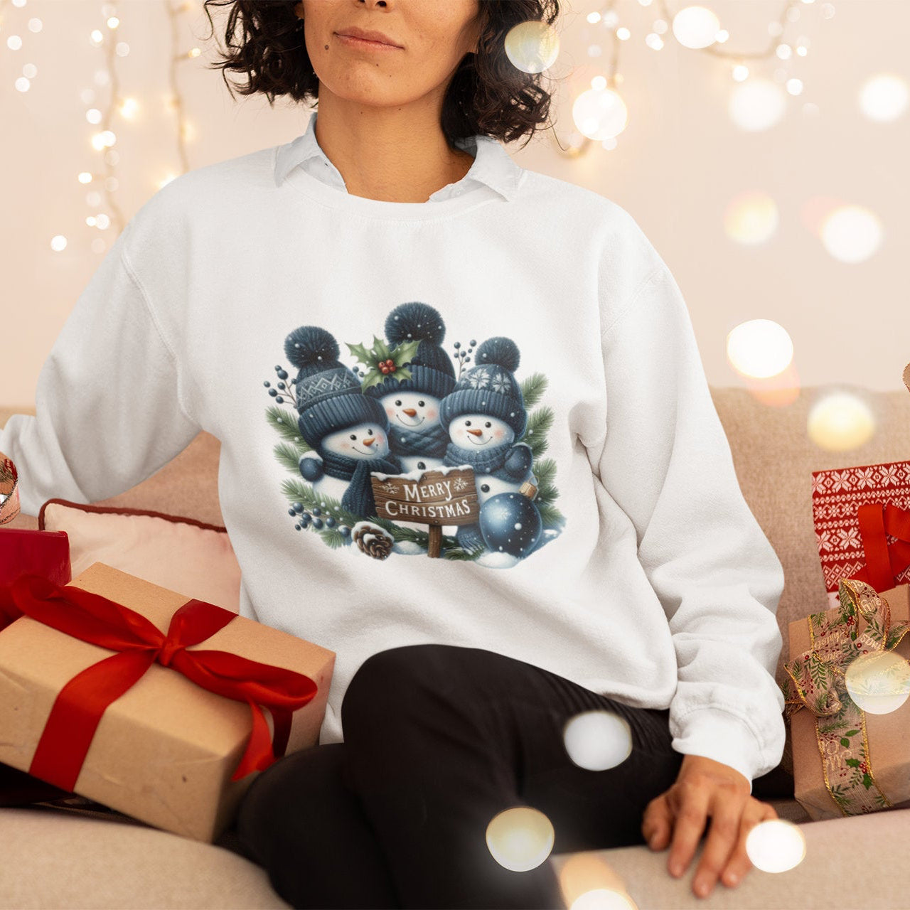 Person wearing a white sweatshirt with Christmas-themed design surrounded by gift boxes and lights.