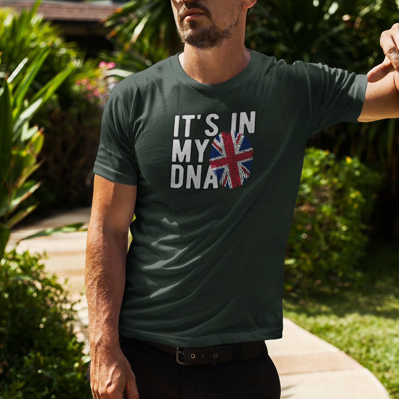 Man wearing a t-shirt with 'It's in my DNA' and a Union Jack design outdoors.
