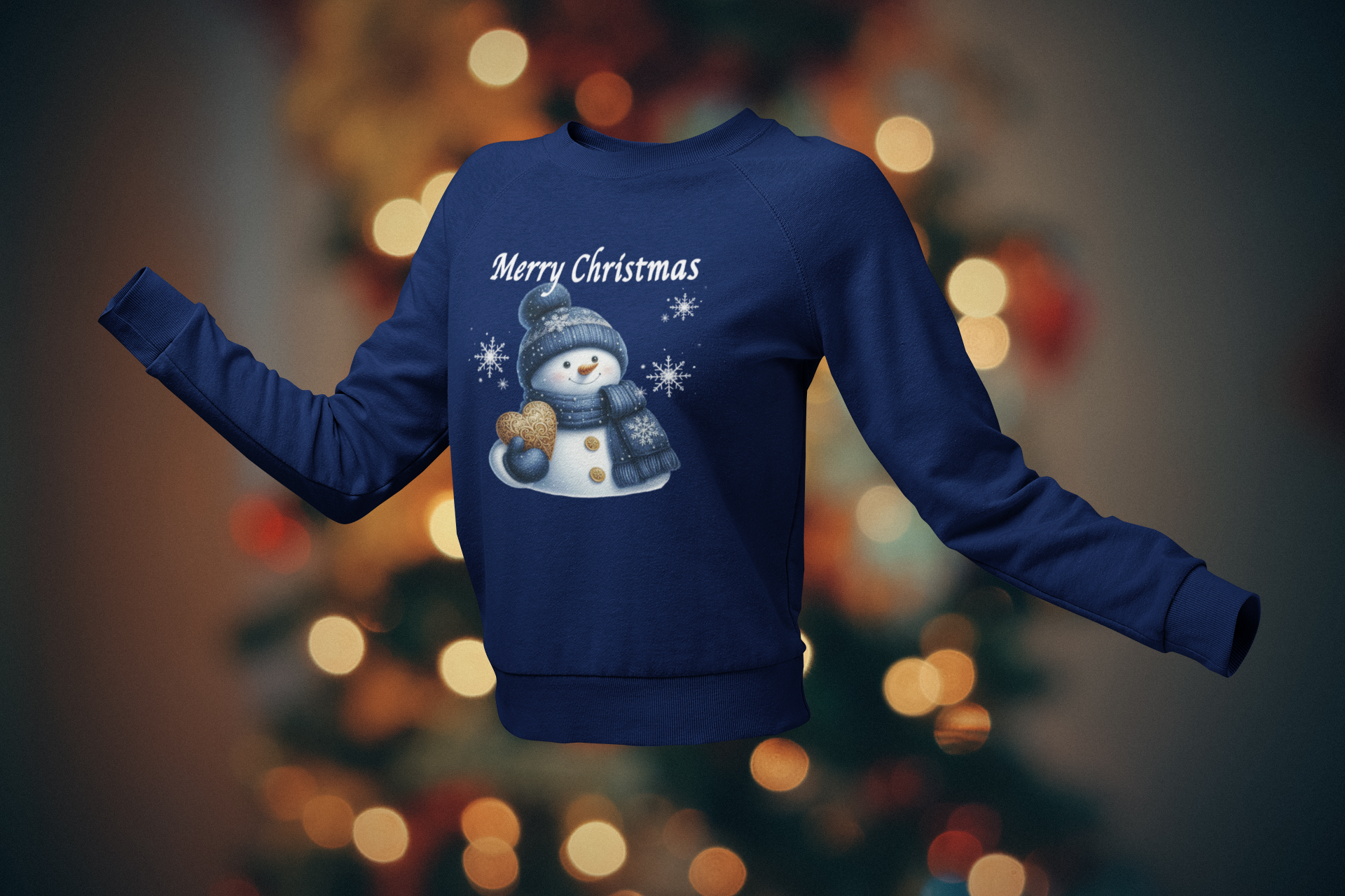 Blue sweatshirt with a snowman design and 'Merry Christmas' text on a blurred Christmas tree background.