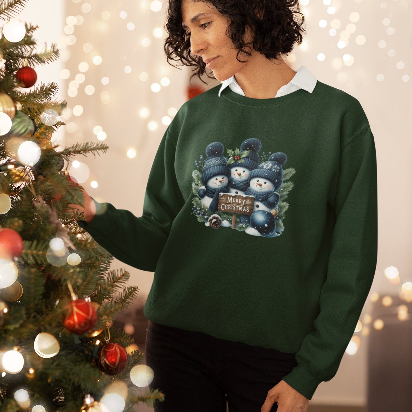 Person wearing a green sweater with a Christmas design in front of a decorated tree.