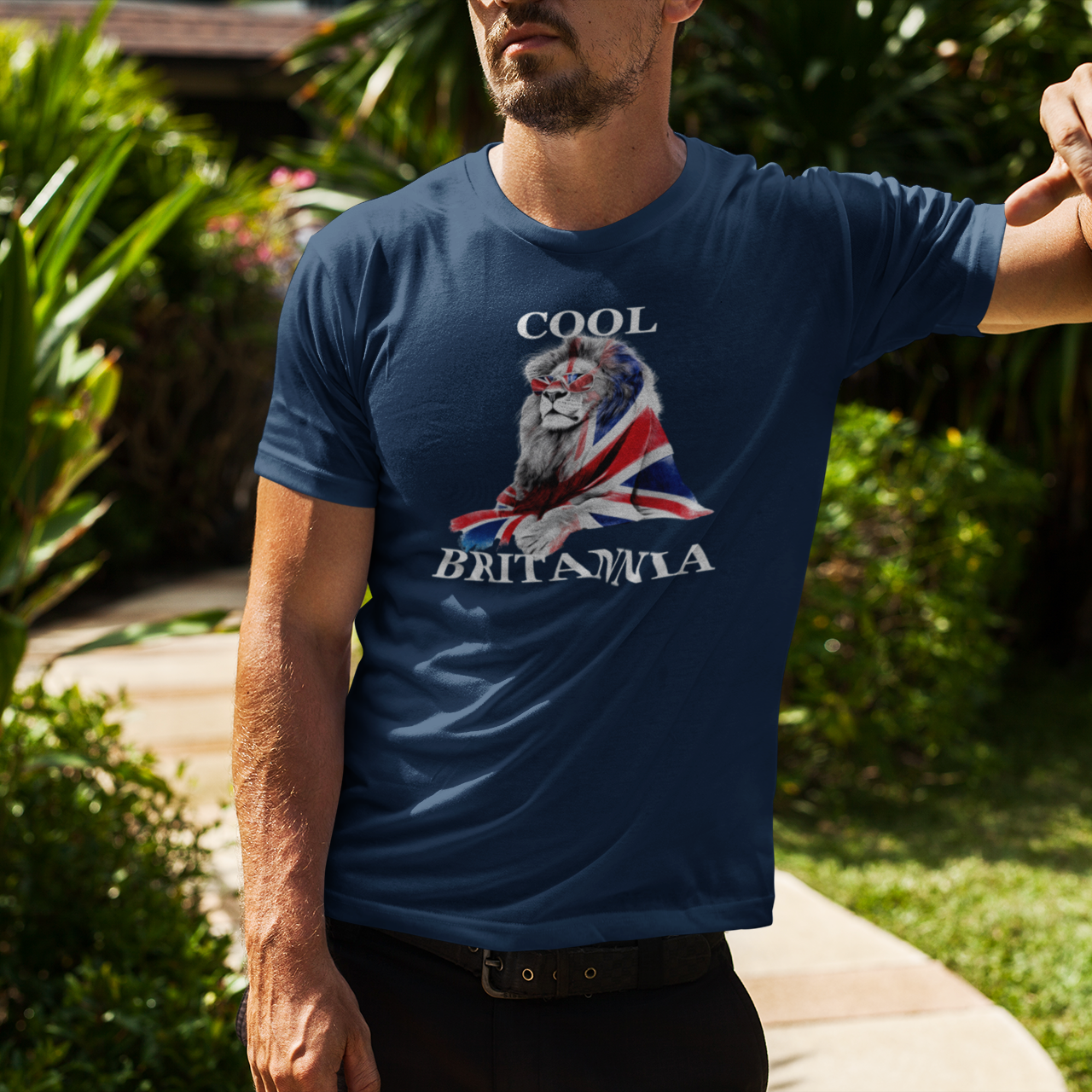 Man wearing a blue t-shirt with a lion and Union Jack design, standing outdoors.