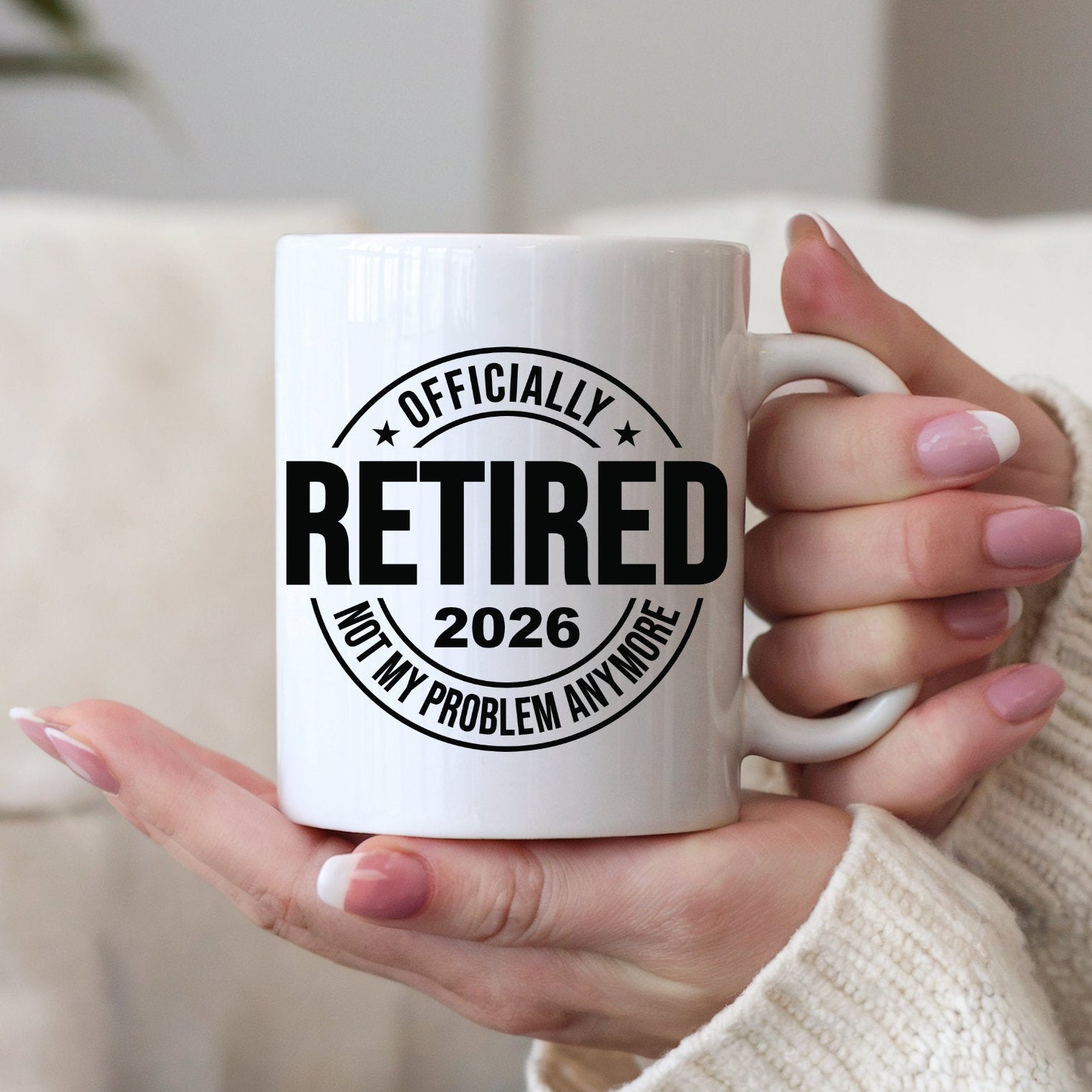 Person holding a white mug with 'Officially Retired 2026 Not My Problem Anymore' text.