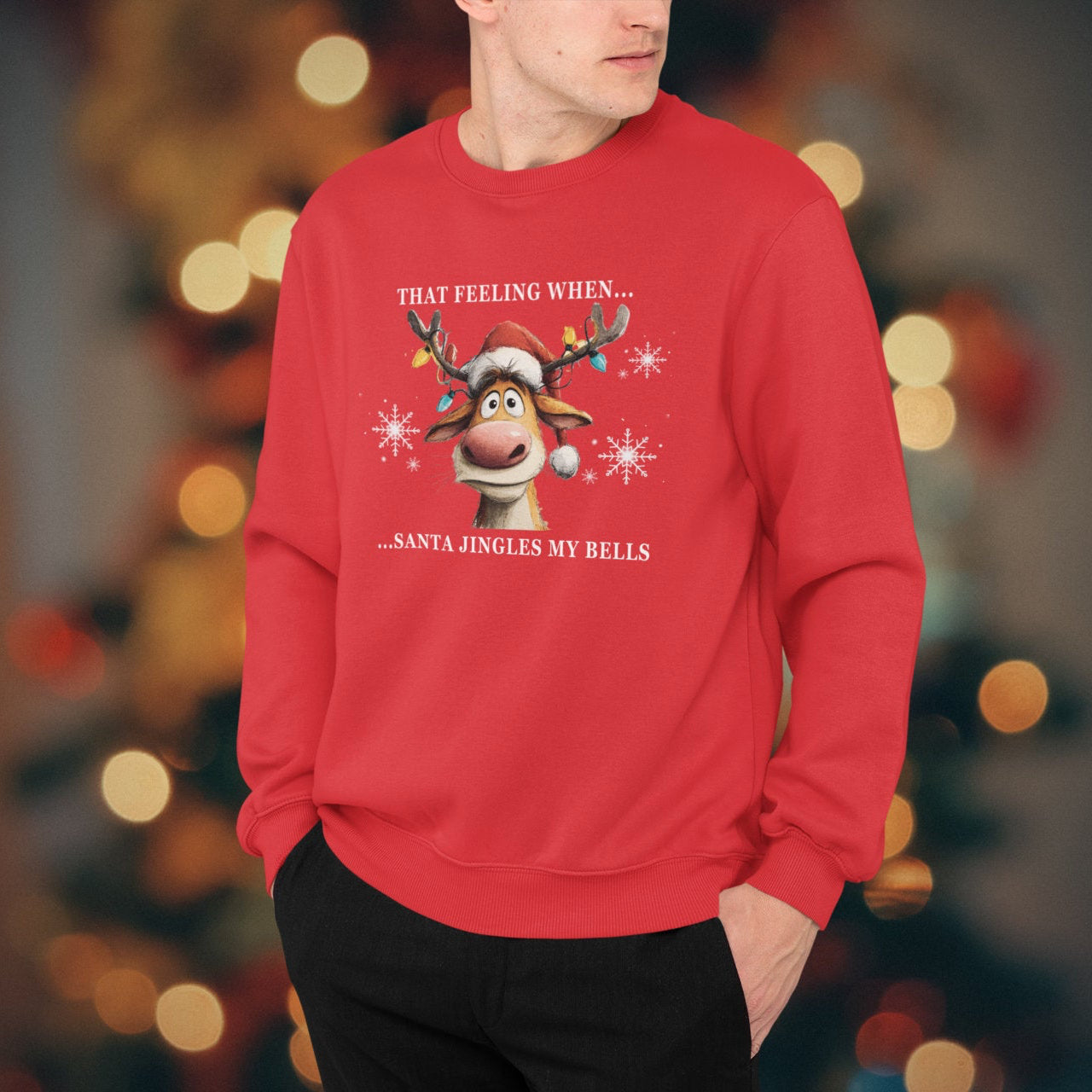 Person wearing a red Christmas-themed sweatshirt with a reindeer graphic and text, against a blurred festive background.
