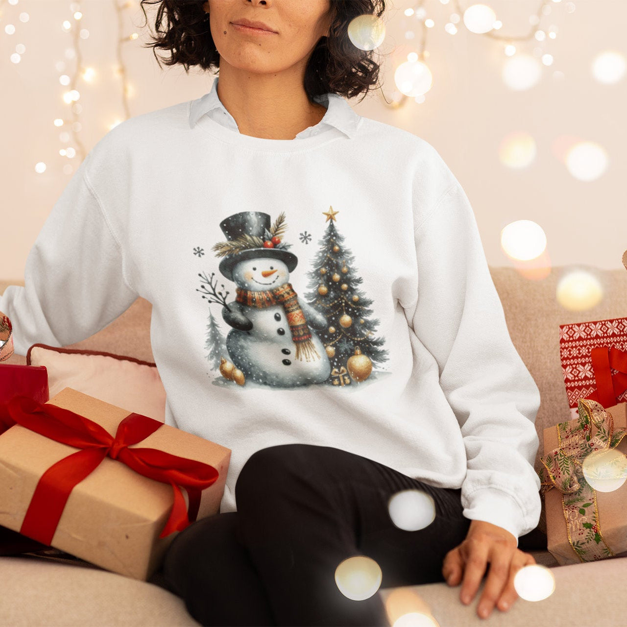 Person wearing a white sweatshirt with a snowman design, surrounded by Christmas presents and lights.
