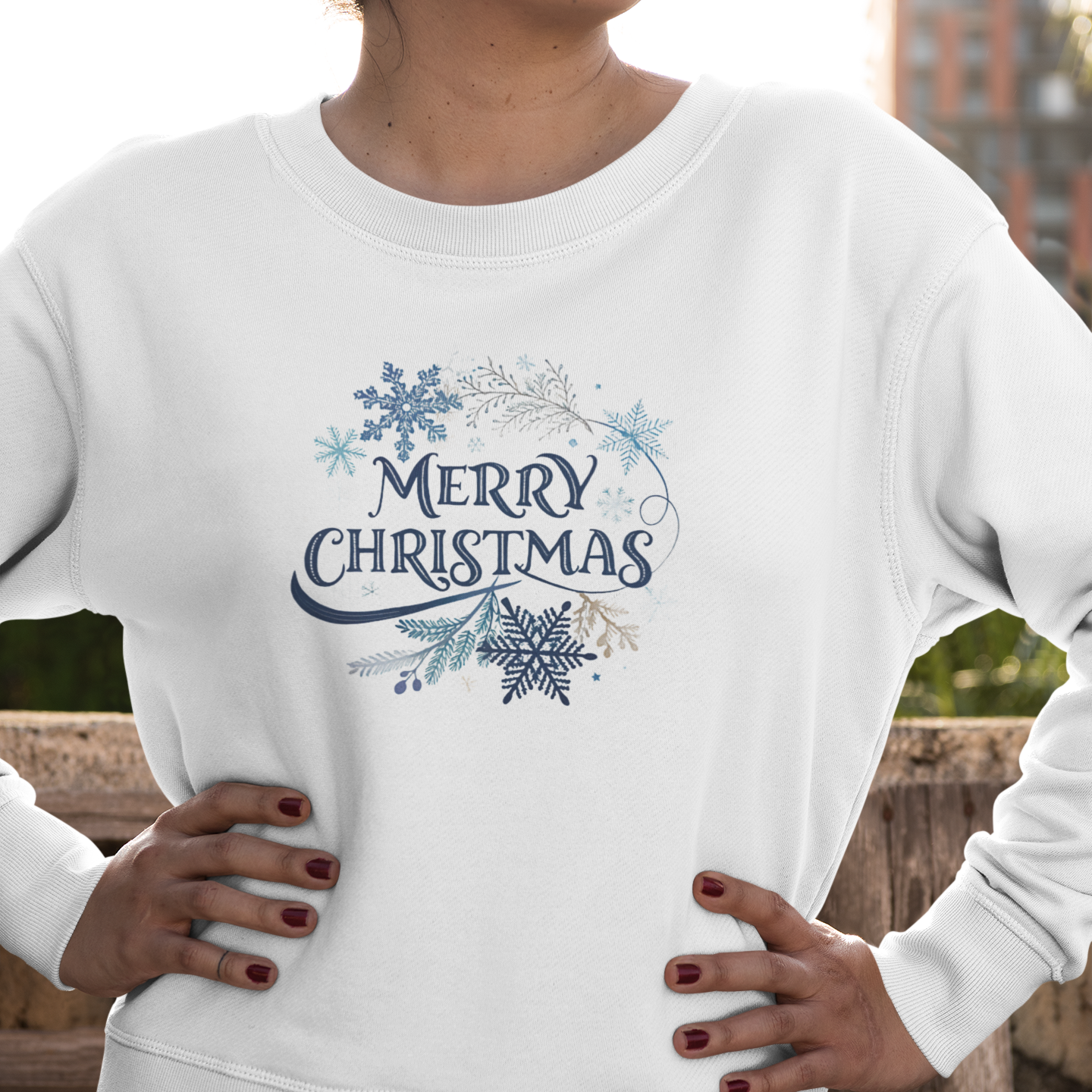 Person wearing a white sweatshirt with 'Merry Christmas' design outdoors.