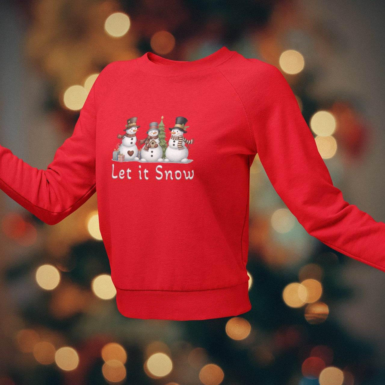 Red sweatshirt with snowman design and 'Let it Snow' text on a blurred Christmas tree background