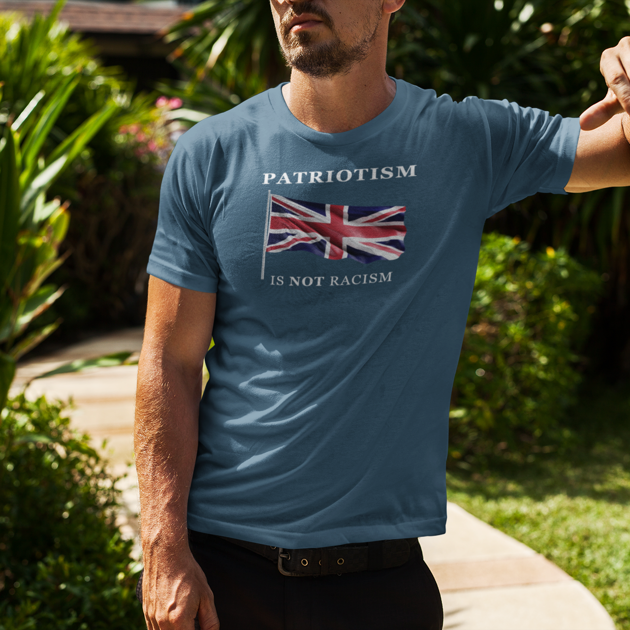 Man wearing a blue t-shirt with a flag design and text in an outdoor setting